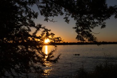 Güneş, Parana nehri adalarının arkasında saklanıyor. 