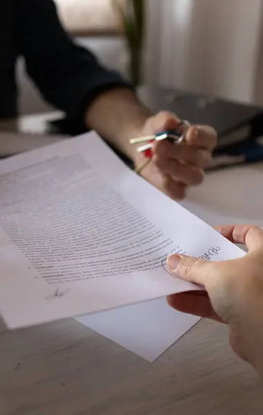 Emlakçı, kira kontratını müvekkiline veriyor.