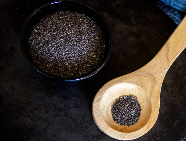 Chia taneleri, vitamin ve omega-3 kaynağı. - Sağlıklı taneler. Yakın plan fotoğraf. Geçmişi karanlık.