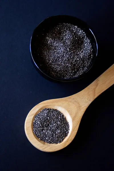 Sağlıklı taneler. Yakın plan fotoğraf. Geçmişi karanlık. Chia taneleri, vitamin kaynağı ve omega-3..