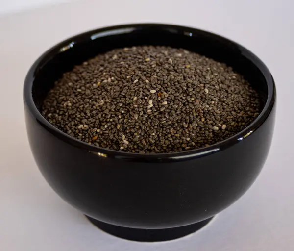 Siyah kasede Chia tohumları. Vejetaryen yemeği. Madenci ve vitamin kaynağı. Sağlıklı tohumlar yiyecek konsepti