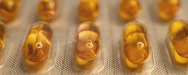 Ascorbic asit. Yumuşak kapsüllerde C vitamini. İlaç tableti ön planda. Sağlıklı bir diyet için gerekli malzemeler.