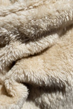 Dekoratif arka plan ya da ürün reklamı. Duvar pedalı. Kopya için alan. Bej tonda kabarık battaniyenin dokusu.. 