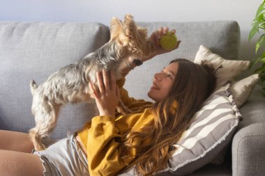Ergen, evde yavrusuyla hoş vakit geçiriyor. Bedava yaşam tarzı konsepti. Sakin ve mutlu anlar. Yavru köpek severler