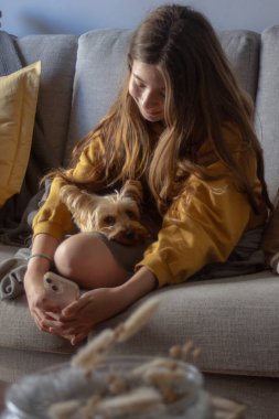 Yavru köpeğiyle evde güzel vakit geçiren bir gencin yakın çekimi. Bedava yaşam tarzı konsepti. Sakin ve mutlu anlar. Yavru köpek severler