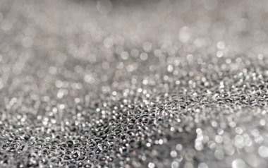 Gümüş parıltılı arka plan maddesi. Yatay bulanık metalik yüzey. Saf gümüş tel örgüler. Parıltılı dalgalı kumaş. Moda ürünlerinin arka planlarında kullanılır.