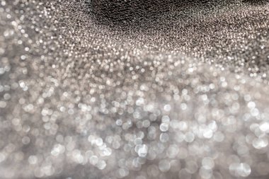 Gümüş parıltılı arka plan maddesi. Yatay bulanık metalik yüzey. Saf gümüş tel örgüler. Parıltılı dalgalı kumaş. Moda ürünlerinin arka planlarında kullanılır.