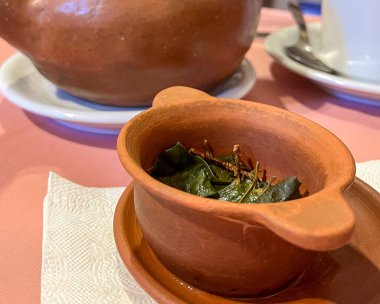 Kokain yaprakları içeren bir kasenin yakın plan fotoğrafı. Mutfak turizminin lezzetleri. Sağlıklı ve sindirimli koka çayı..