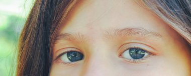 Yatay bir şekilde kameraya bakan kızın görüntüsü. Kafkasyalı kızın güzel mavi gözleri. Kaliteli fotoğrafçılık, antika.