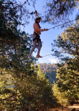  Tırmanış parkı. Yüksek ipli macera sporu. Macera sporu. Ormanda eğlence turizmi. Gerçek fotoğraf. Gençler için turizm ve macera sporlarının tanıtımı. 