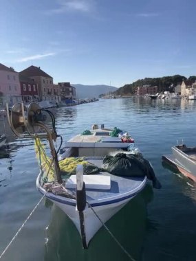 Deniz sakin ve güneşli bir sabahta tekneyi sallar. Hvar adasındaki yat limanı. Rahat seyahat ve tatil konsepti. Yaz turizmi promosyonları için kullanılır. Tam HD görüntüler.