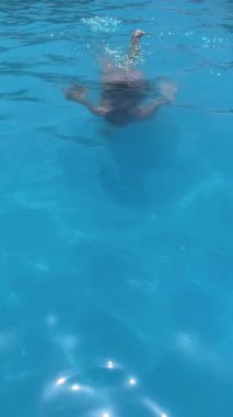 Havuzda eğlenen bir kız. Yaz seyahati ve turizm. Dikey 4K görüntü. Yaz ve tatil kavramları. Mesaj için boşluk.