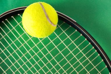 Tenis raketi ve toplar parlak yeşil arka planda, düz. Kopyalama alanı olan üst görünüm. Tenis sporu promosyonu için arka plan. Gerçek yatay resim. 