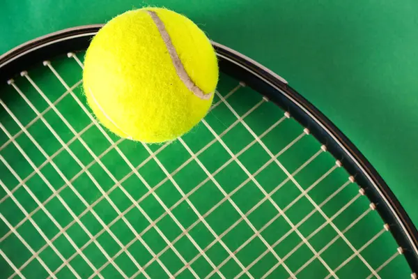 Tenis raketi ve toplar parlak yeşil arka planda, düz. Kopyalama alanı olan üst görünüm. Tenis sporu promosyonu için arka plan. Gerçek yatay resim. 