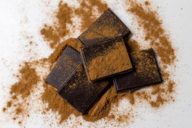 Üzerine sinamon veya kakao tozu serpiştirilmiş lezzetli siyah çikolata parçaları. Tarif görselleri, sanatsal markalaşma ya da kırsal tatlı promosyonları için ideal. Bayram tarifi grafikleri ve mevsimsel duyurular için mükemmel bir seçim.