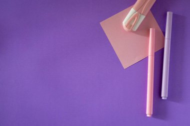 Minimalist mor arka planda organize okul malzemelerinin en üst görüntüsü. Eğitim, e-öğrenme ya da akademik temalı görsel materyaller için mükemmel. Kimse yok..