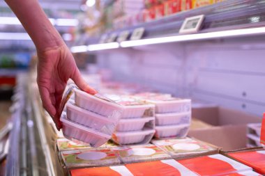 Kadının eli süpermarkette natto seçiyor.