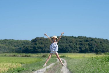 Genç Asyalı kız kırsalda atlarken eğleniyor.