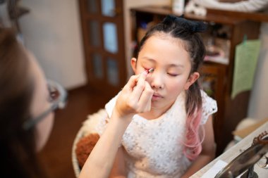 Kızı annesinden makyaj öğreniyor.