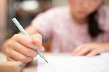 Asyalı kız ödevini evde yapıyor