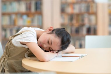 Çalışırken başını eğen bir kız.