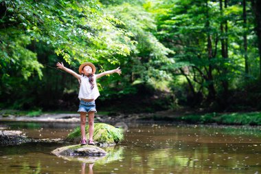 Parkta nehir kenarında dinlenen tatlı bir kız. 