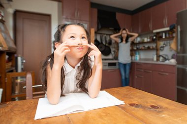 Asyalı kız ödevini evde yapıyor 