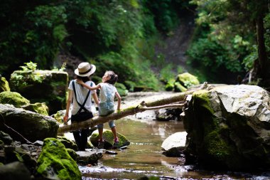 Anne ve kızı bir dağ deresinde oynuyorlar.