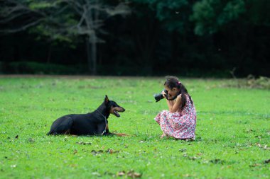 Doberman 'ın fotoğrafını çeken kız.