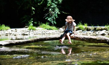 Parkta nehir kenarında dinlenen tatlı bir kız. 