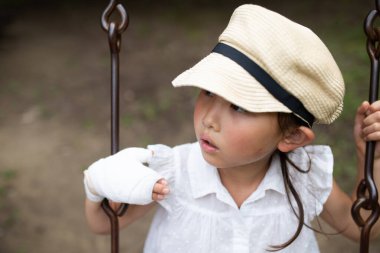 Elinde bandaj olan çocuk.