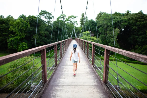 Girl walking on suspension bridge