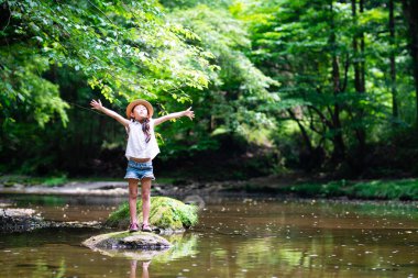 Parkta nehir kenarında dinlenen tatlı bir kız. 