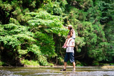 Baba ve kızı nehirde oynuyorlar.