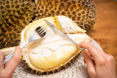 Bıçak ve çatalla Durian ve Eller 