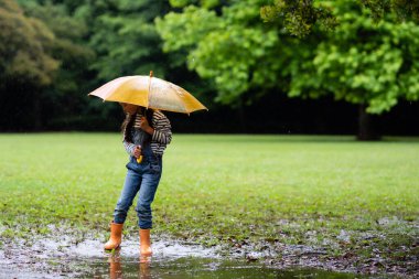 Sonbahar sezonunda parkta şemsiyeli Asyalı kız