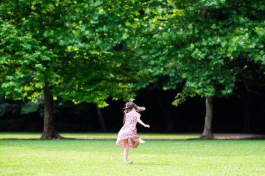 Genç kız yaz parkında koşuyor.