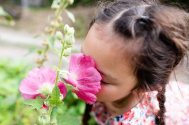 Çiçek kokusu alan bir kız.