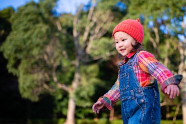 young asian girl having fun  in autumn park 