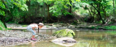 Dağ deresinde oynayan kız