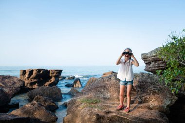 Kumsalda dürbünlü tatlı Asyalı kız. 