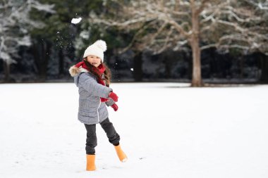 Mutlu çocuk parkta karda oynuyor.