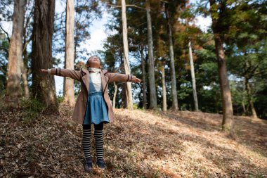 Kışın ormanda oynayan kız.