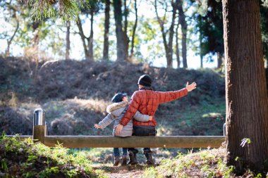Baba ve kızı ormanda oynuyorlar.