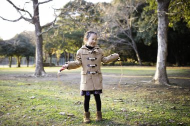 Sonbahar parkında ip atlayan kız