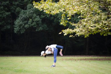 Anne ve kızı parkta egzersiz yapıyor.