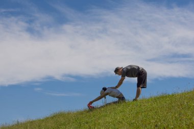 Çimlerde egzersiz yapan bir çift.