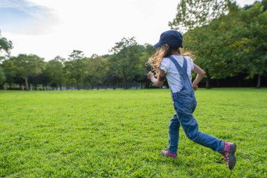 Genç Asyalı kız parkta eğleniyor. 