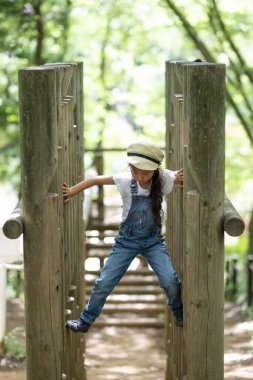Parkta oyun parkında oynayan küçük tatlı Asyalı kız.