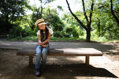 Kız bankta oturuyor.